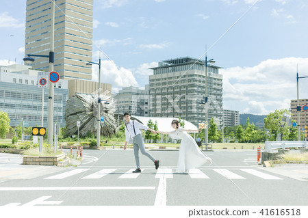 Bride and groom walking down the street Bride and groom walking down the street 41616518