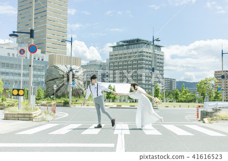 Bride and groom walking down the street Bride and groom walking down the street 41616523
