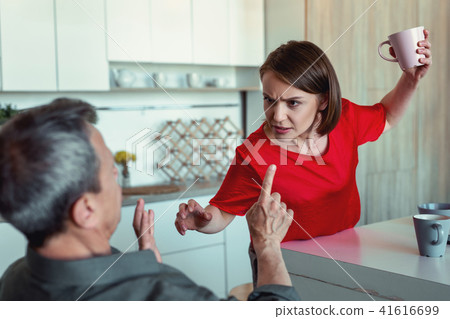 Concerned stressed wife cocking her husband with cup Concerned stressed wife cocking her husband with cup 41616699