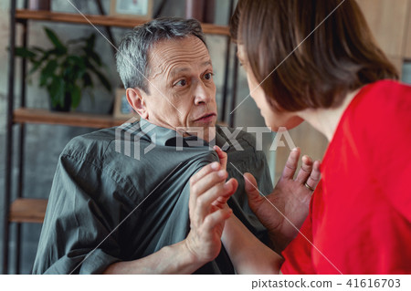 Concerned wife grabbing her husband having dispute 41616703
