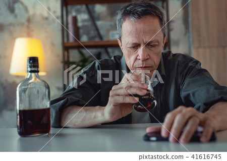 Grey-haired man feeling in despair suffering from alcohol addiction 41616745