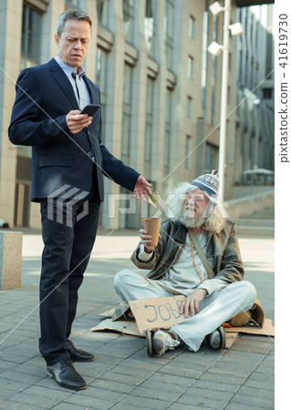 lderly rich businessman giving some money to poor man 41619730