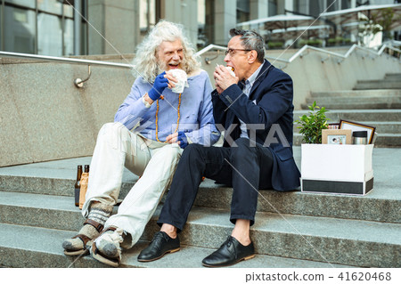 Office worker communicating with street hippy after dismissal Office worker communicating with street hippy after dismissal 41620468