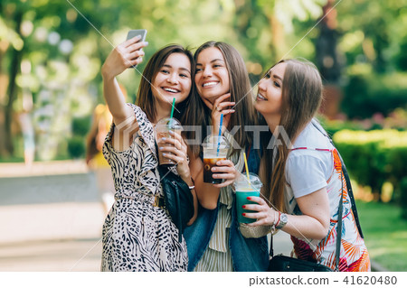 Happy friends in the park on a sunny day . Summer lifestyle portrait of three multiracial women Happy friends in the park on a sunny day . Summer lifestyle portrait of three multiracial women 41620480