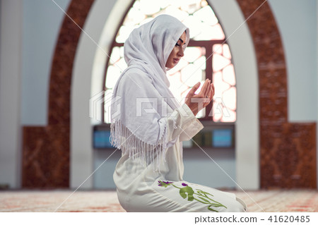 Arabic Young muslim woman praying in mosque 41620485