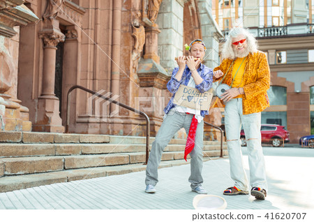 Two bright positive men dancing and singing together Two bright positive men dancing and singing together 41620707