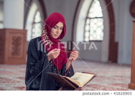 Young muslim woman praying with rosary in mosque 41620903