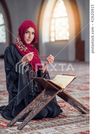 Young muslim woman praying with rosary in mosque 41620915