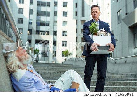 Fired man leaving office seeing homeless man 41620981