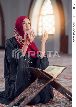 Young muslim woman praying with rosary in mosque 41621017