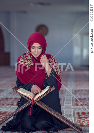 Muslim Woman Reading Koran Or Quran Wearing Traditional Dress At The Mosque Muslim Woman Reading Koran Or Quran Wearing Traditional Dress At The Mosque 41621057
