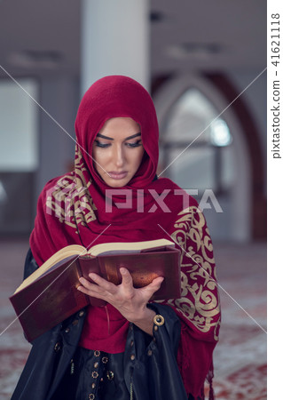 Muslim Woman Reading Koran Or Quran Wearing Traditional Dress At The Mosque Muslim Woman Reading Koran Or Quran Wearing Traditional Dress At The Mosque 41621118
