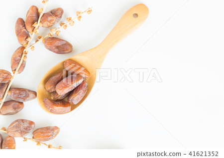 Dates fruit in wooden ladle on white background Dates fruit in wooden ladle on white background 41621352