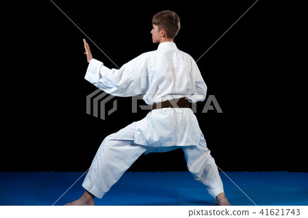 Young boy training karate on black background Young boy training karate on black background 41621743