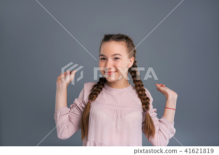 Cute cheerful girl raising her hands happily Cute cheerful girl raising her hands happily 41621819
