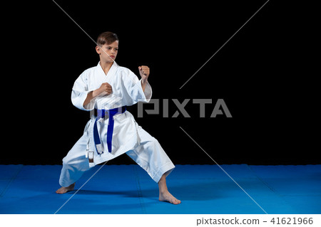 Pre-teen boy doing karate on a black background 41621966