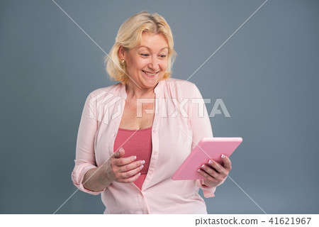 Joyful middle-aged woman smiling having read message Joyful middle-aged woman smiling having read message 41621967
