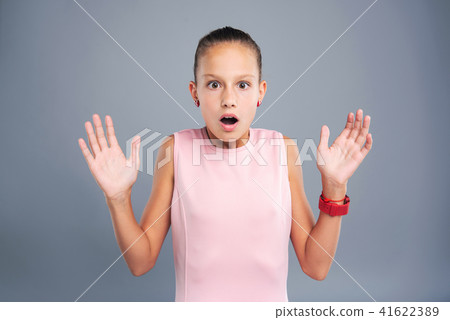 Petite teenage girl looking scared by something - Stock Photo