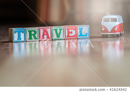 Small toy car and wooden blocks spelling travel 41624842