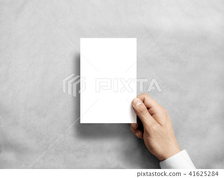 Hand holding blank white vertical postcard flyer mockup. 41625284
