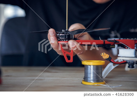 Photo of man with screwdriver cleaning quadrocopter 41628300