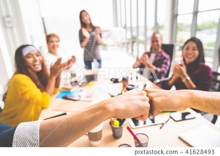 Coworkers fist bump in meeting, teamwork concept Coworkers fist bump in meeting, teamwork concept 41628493