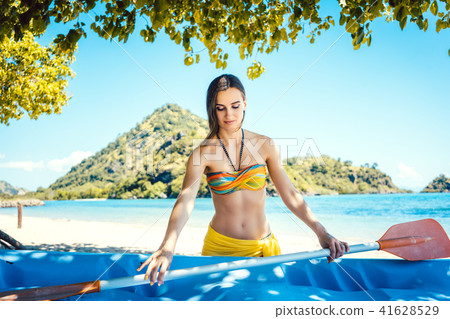 Woman with a kayak on an island in front of beach 41628529