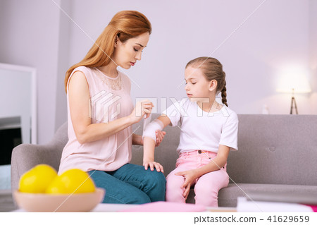 Serious young woman holding her daughters hand 41629659