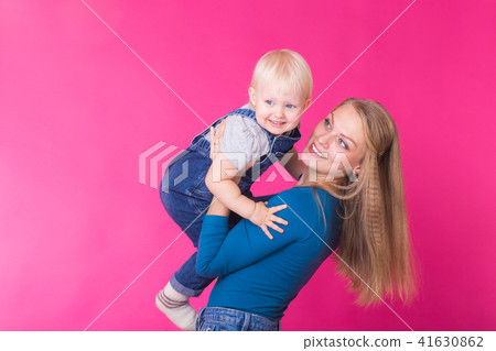 Funny family on pink background. Mother and her daughter girl. Mom and child are having fun. Funny family on pink background. Mother and her daughter girl. Mom and child are having fun. 41630862