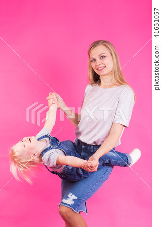 happy little girl and her mother having fun over pink background happy little girl and her mother having fun over pink background 41631057