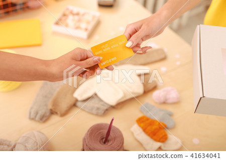 Young mother paying for baby clothes by card Young mother paying for baby clothes by card 41634041