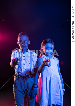 Unsmiling boy and a girl tapping imaginary buttons 41634241