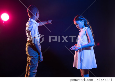 Alert girl and a boy playing an imaginary piano Alert girl and a boy playing an imaginary piano 41634281
