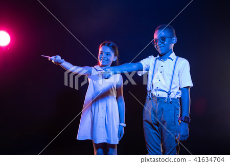 Pleased kids holding their remote controls Pleased kids holding their remote controls 41634704