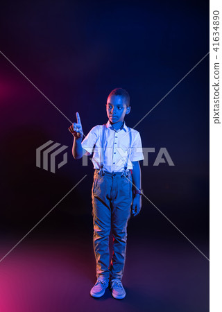 Serious little boy pressing imaginary buttons 41634890