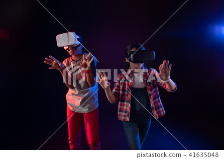 Happy girl and a boy wearing VR headsets 41635048