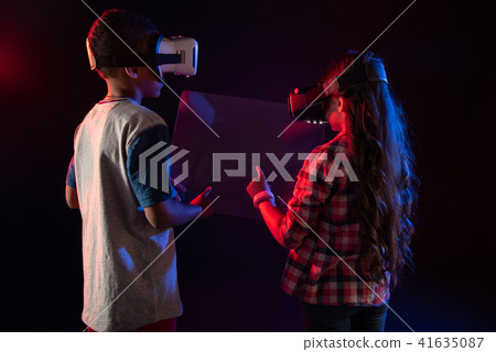 Interested boy and a girl playing VR games 41635087