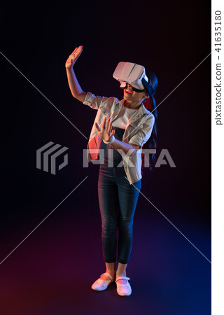 Joyful schoolgirl wearing a VR headset 41635180