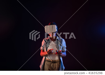 Content boy wearing a modern VR headset Content boy wearing a modern VR headset 41635298