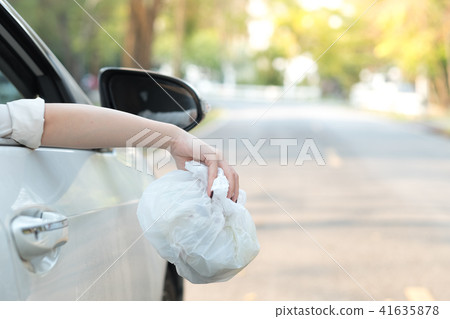 Hand throwing plastic bag on the road Hand throwing plastic bag on the road 41635878