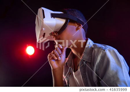 Unsmiling schoolboy wearing a modern VR headset Unsmiling schoolboy wearing a modern VR headset 41635999