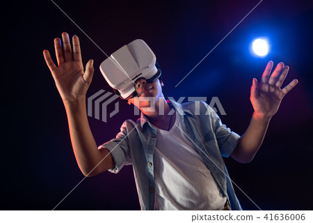 Cheerful teenager wearing a modern VR headset Cheerful teenager wearing a modern VR headset 41636006