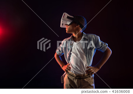 Thoughtful teenager wearing a modern VR headset Thoughtful teenager wearing a modern VR headset 41636008