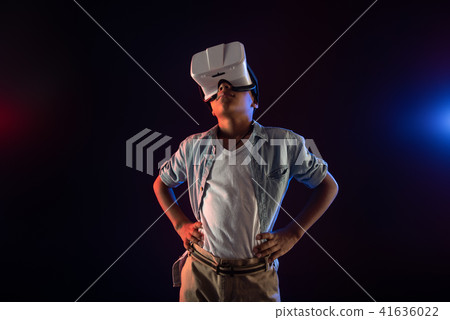 Preoccupied teenager wearing a modern VR headset 41636022