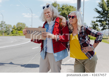 Joyful aged people standing near the road Joyful aged people standing near the road 41637457