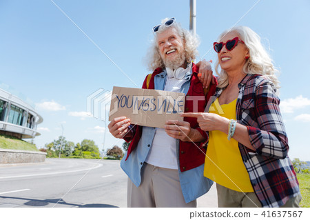 Delighted aged woman pointing at the sign 41637567