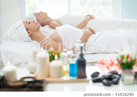 Relaxed young woman lying on spa bed for massage. Relaxed young woman lying on spa bed for massage. 41638290