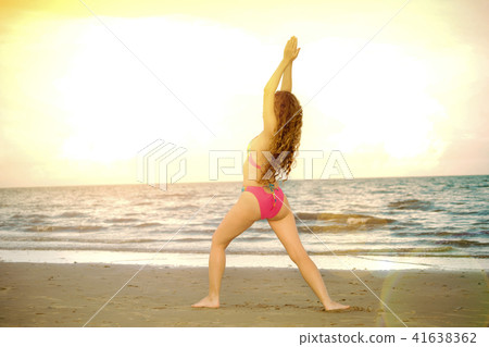Young woman practices yoga on the beach in summer. Young woman practices yoga on the beach in summer. 41638362