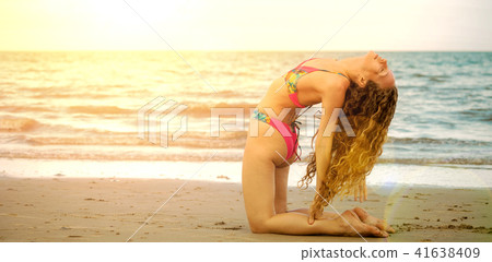 Young woman practices yoga on the beach in summer. Young woman practices yoga on the beach in summer. 41638409