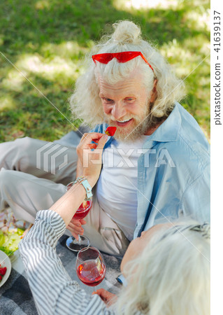 Delighted nice man eating a strawberry Delighted nice man eating a strawberry 41639137